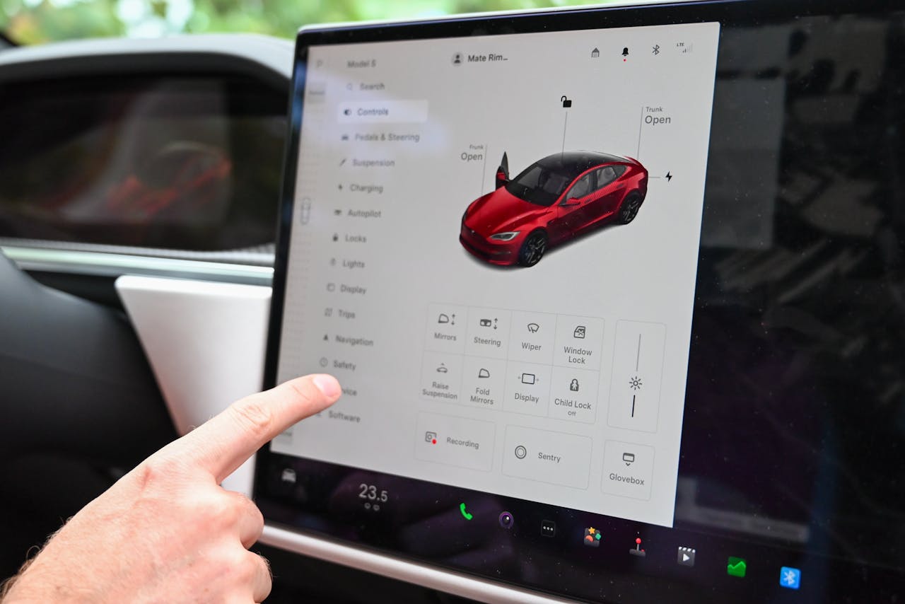 contact-img Close-up of a hand interacting with a modern car's touchscreen interface for various controls.