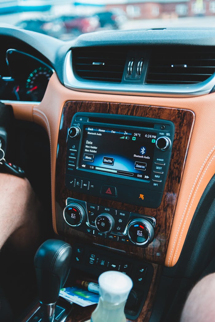 Radio in automobile with inscriptions on bright screen near transmission and dashboard
